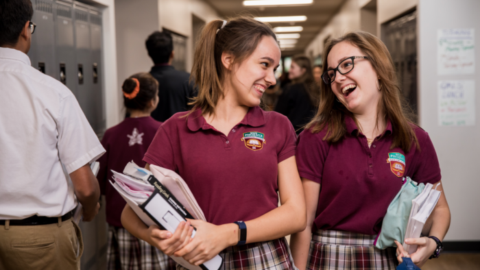 2 students laughing in hallway