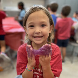 Young student playing with slime at summer camp