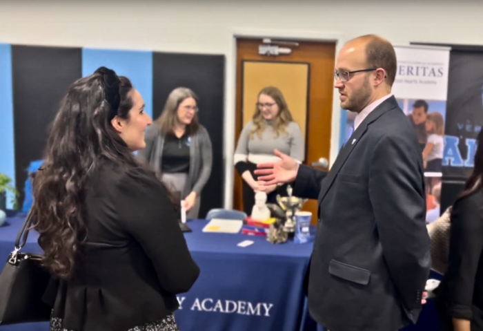 School leader speaking with candidate at hiring event