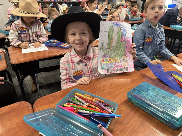 Cicero student dressed like a pioneer with an art project for Arizona's birthday.
