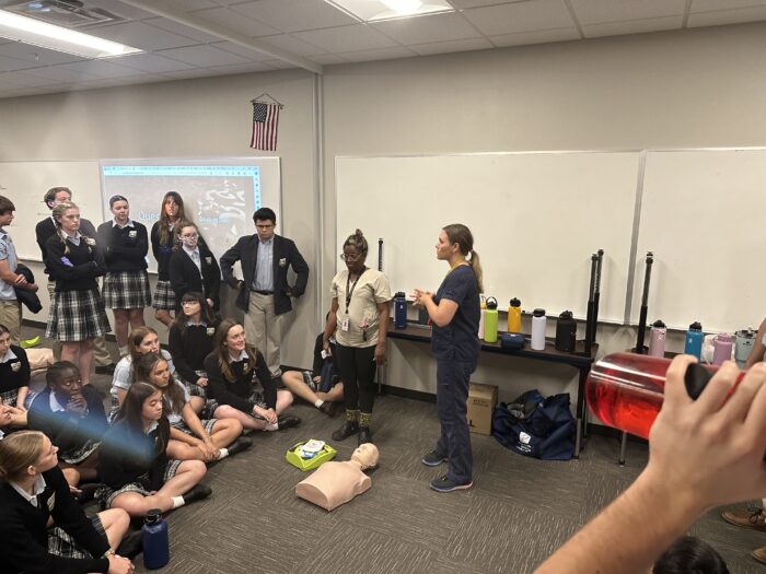 Nurse giving CPR demonstration to group of seniors