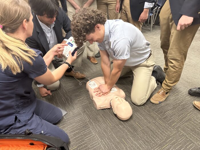 Student performing CPR simulation on a mannequin