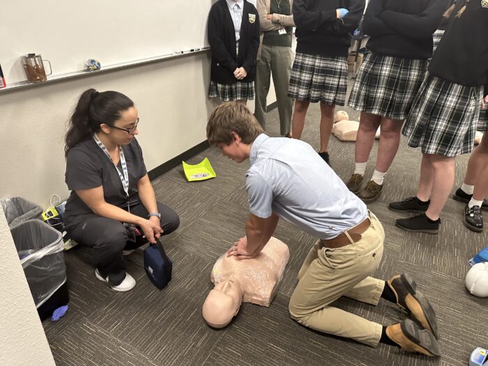 Student performing CPR simulation on a mannequin