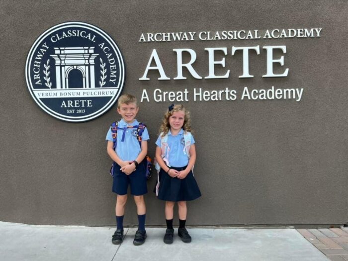 Two students in front of Archway Arete sign on first day of school