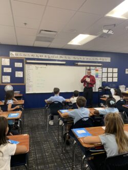 Teacher with cue cards in front of his class