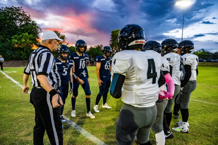 Glendale Prep Griffin football players on field with a referee for coin toss