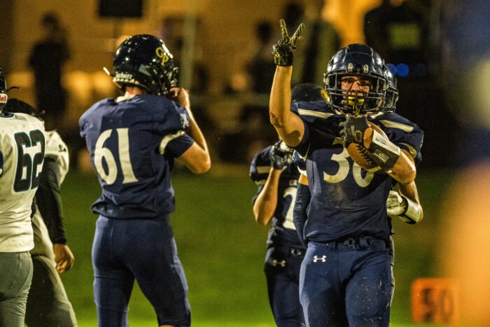 Glendale Prep Griffin football player giving a peace sign and holding the ball