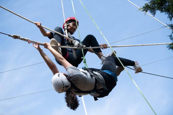 Two female students on a rope challenge