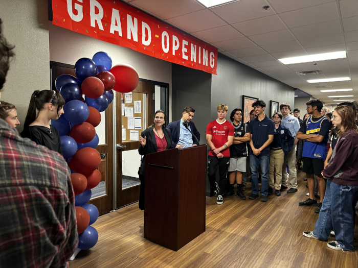 Female behind a podium with students looking on