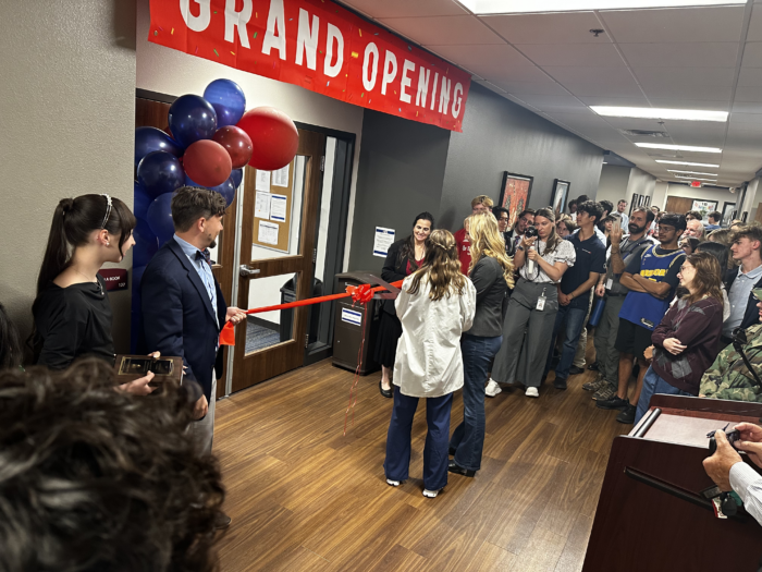 Ribbon cutting ceremony with students and faculty looking on