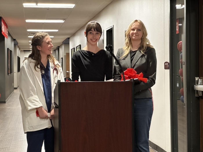 Three female students behind a podium