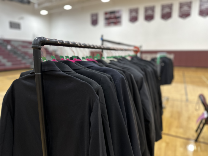 A row of blazers on a coat rack