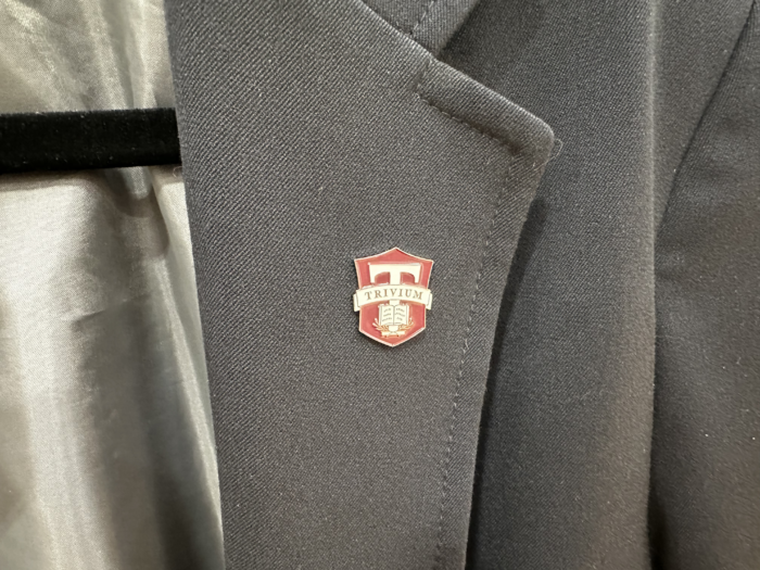 A blazer collar with a Trivium lapel pin