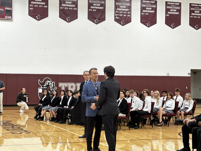 student shaking hands with a faculty member