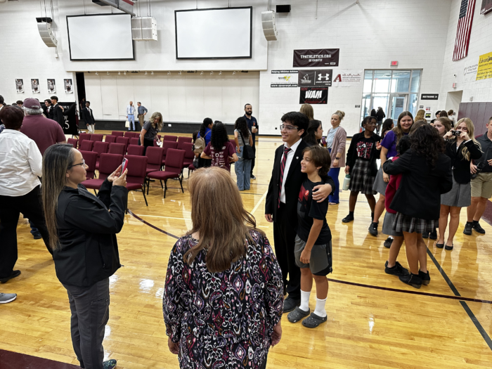 Parent taking a photo of their student