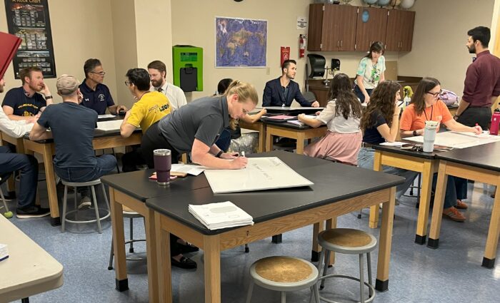 Small group of teachers and faculty in a science classroom with lab tables