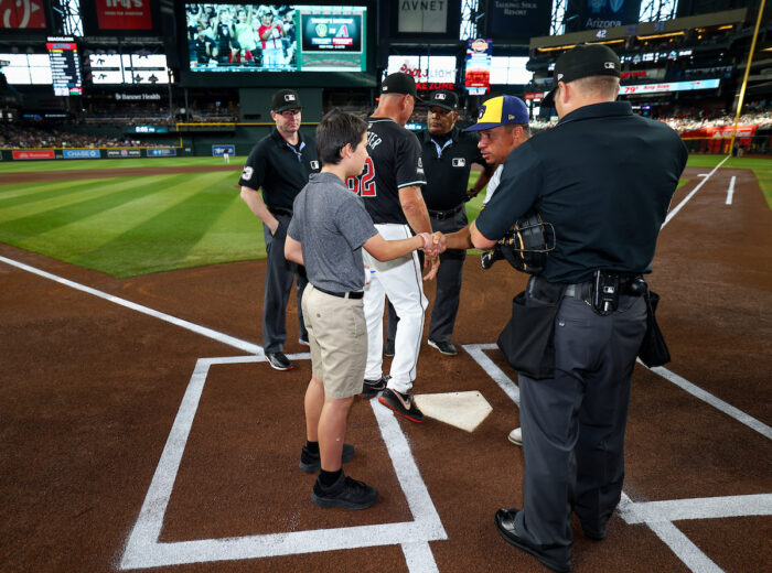 Students at home plate shaking a player's hand