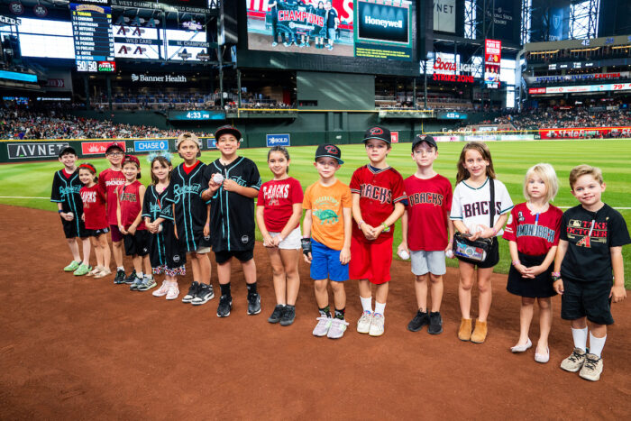 Students with D-backs jerseys standing in a line on a ball field