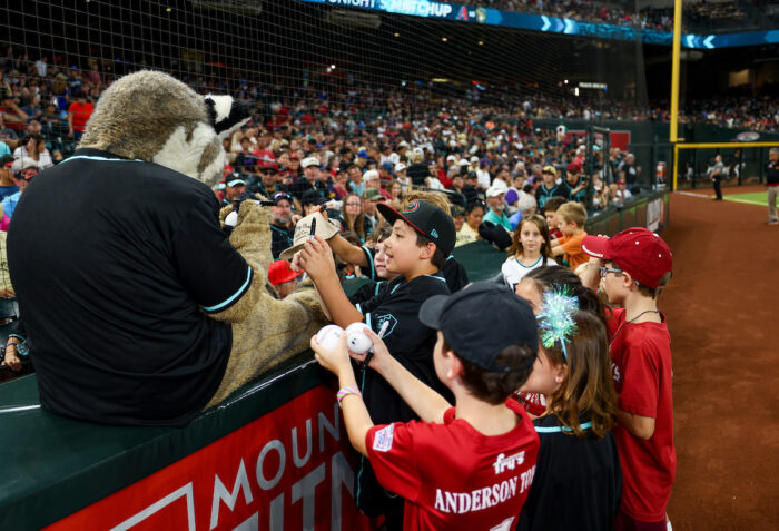 Students getting autographs from a mascot