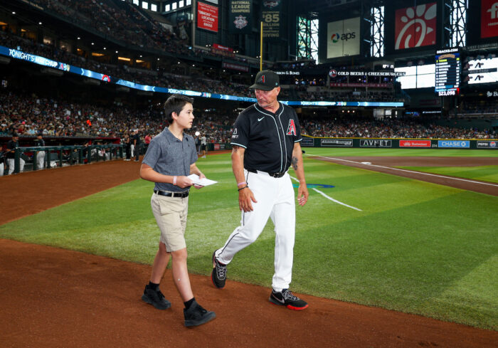 Student walking with a coach on the ball field