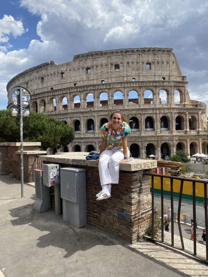 women sitting in front of Colosseum