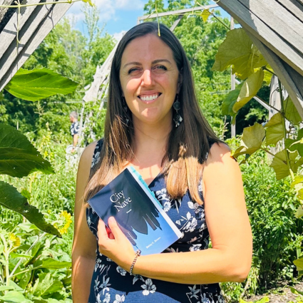 Betsy Brown hold her book in a garden