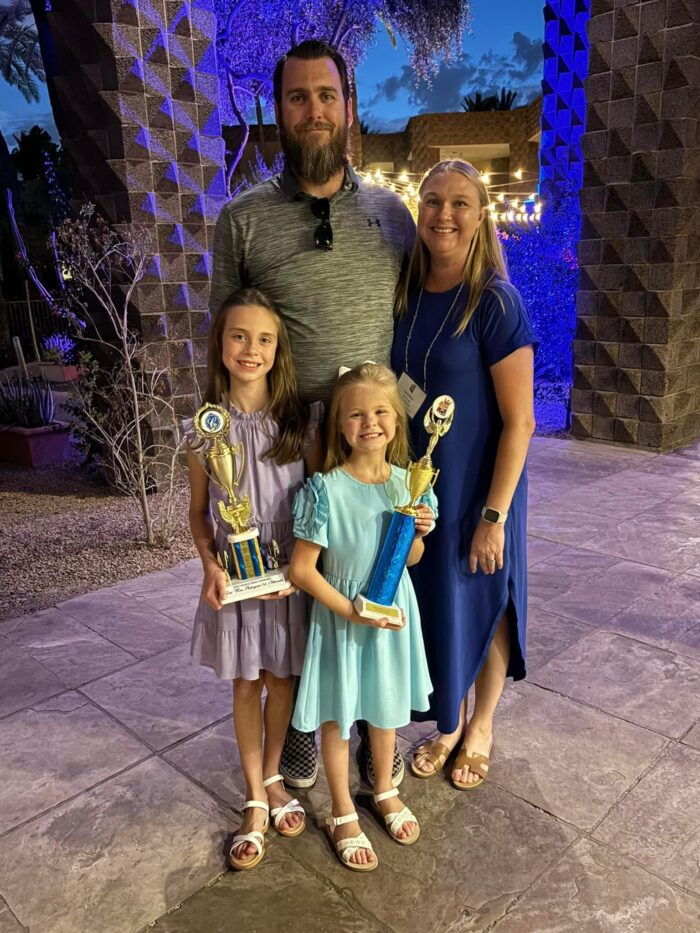 Headmaster Thomas Taylor with his family, daughters holding trophies