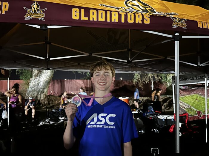 Student runner holding a medal