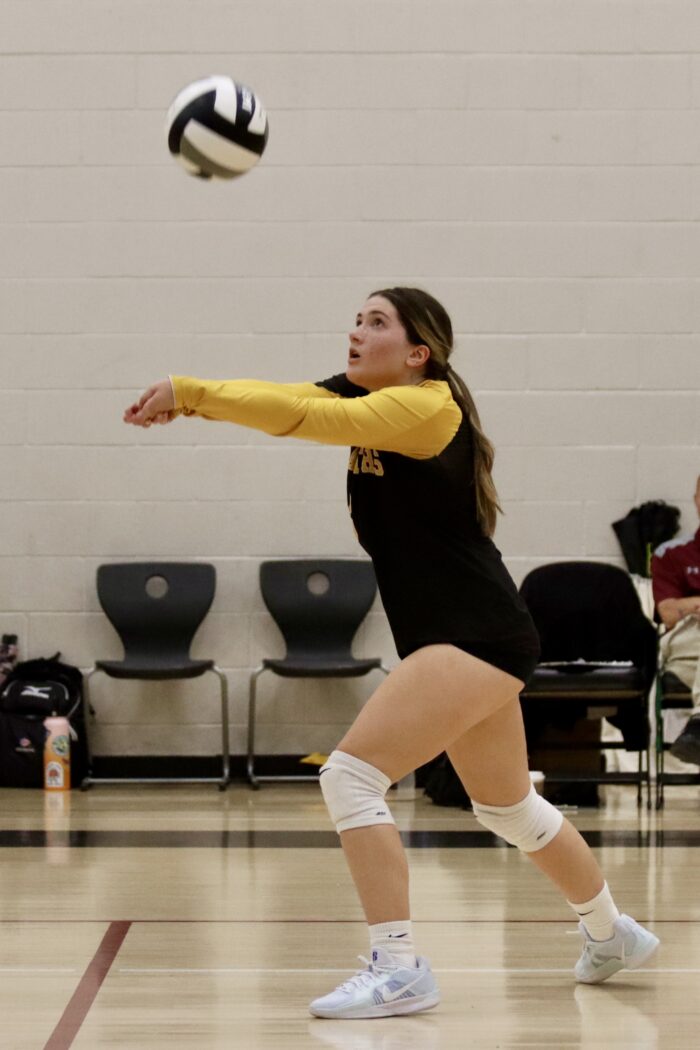 A female high school student playing volleyball