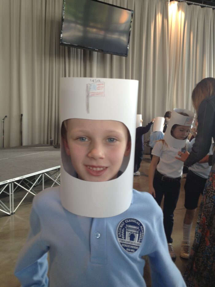 An archway student wearing a paper helmet