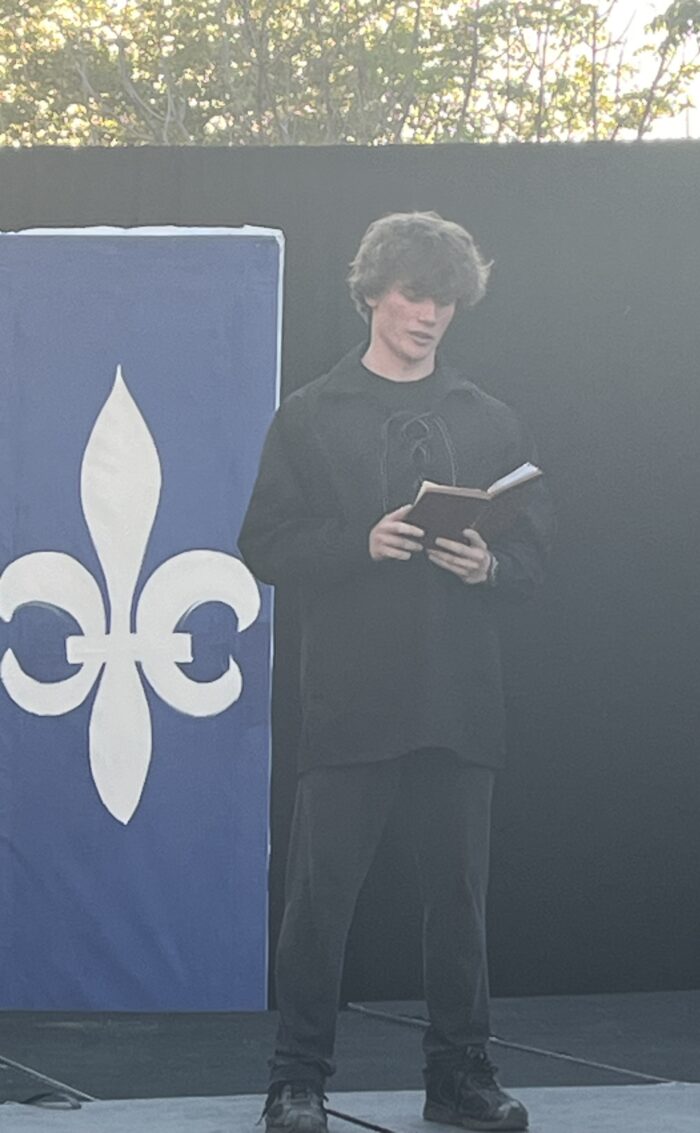 High school student reciting out of a book