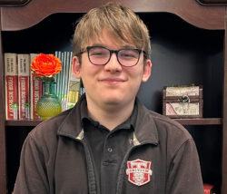 male student in front of bookcase