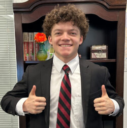 Student in blazer giving a thumbs up