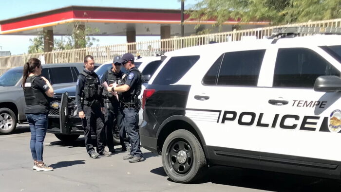 Police officers gathered behind a Tempe Police vehicle