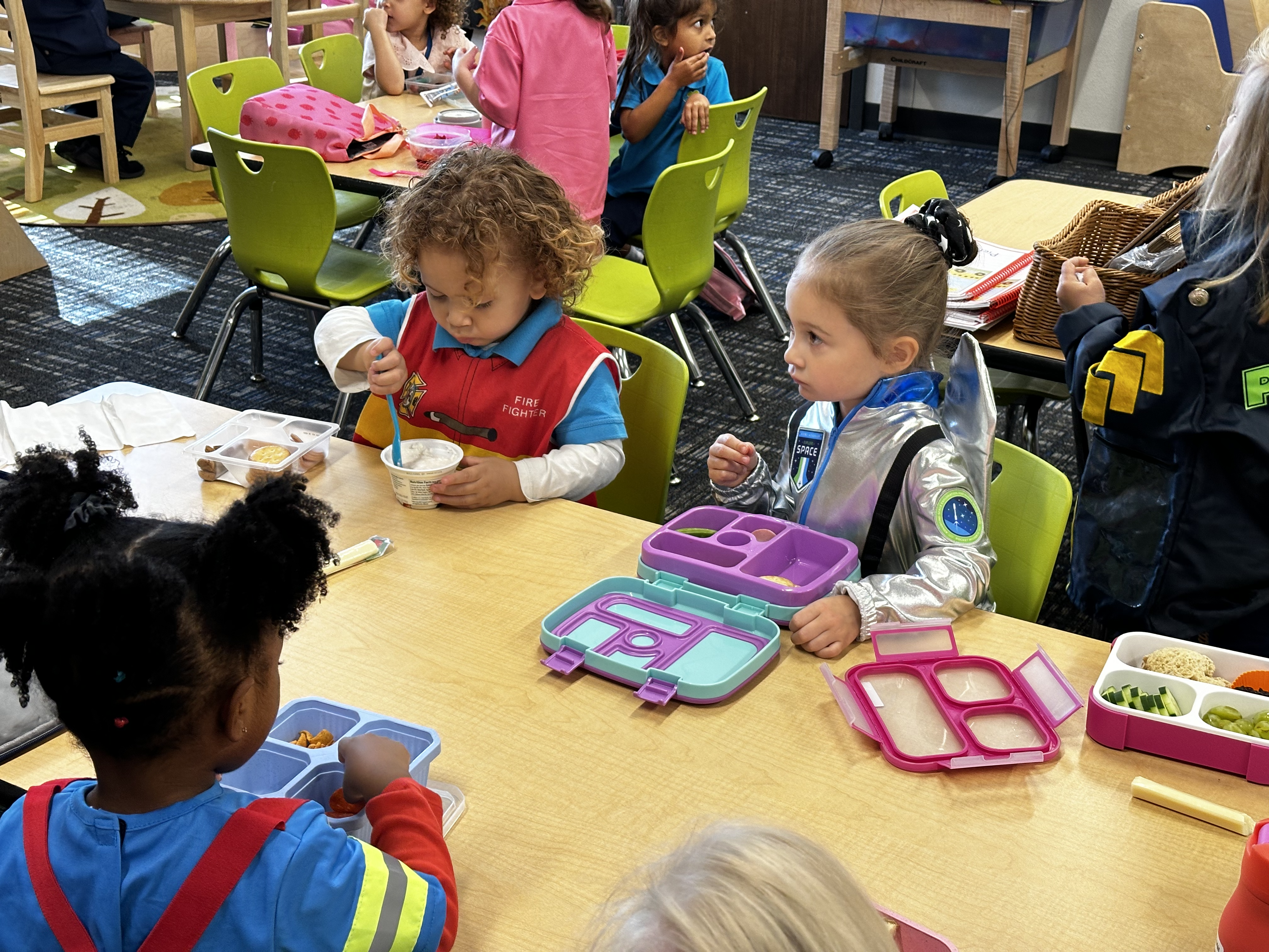 Preschoolers in costumes eating lunch at a table