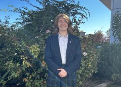 Veritas senior with blazer standing in a rose garden