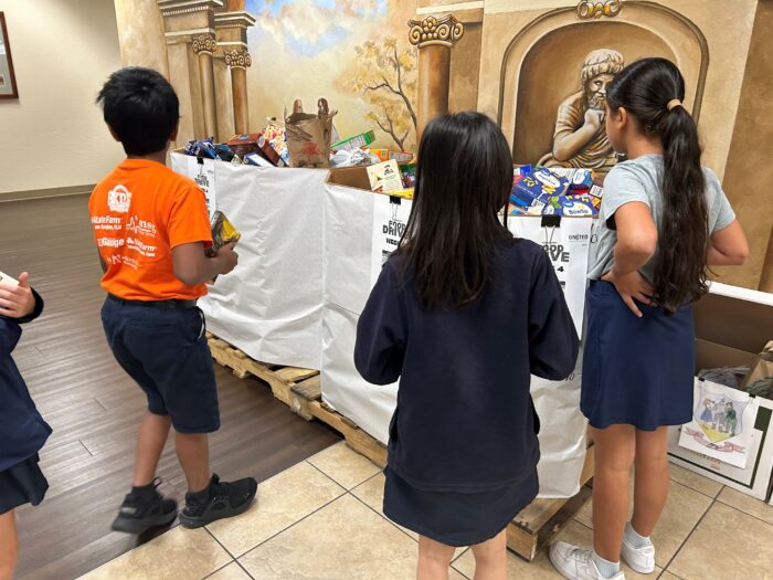 Students standing in front of donation bins