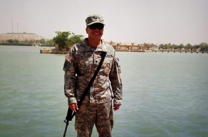 Man in military uniform in front of a body of water