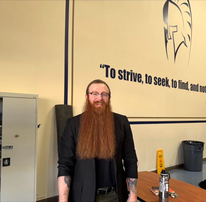 Dr. James Hall standing in front of a mural