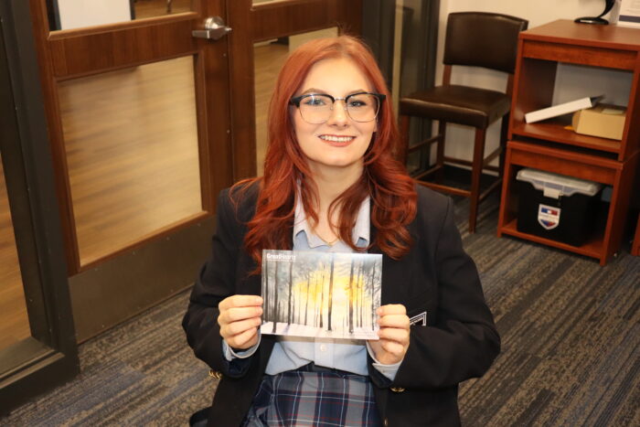 Student posing with her artwork