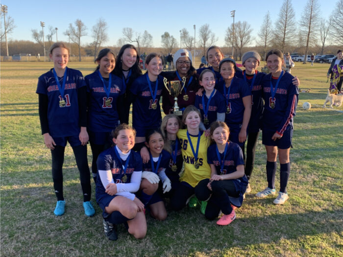 Harveston girls soccer team posing with championship trophy