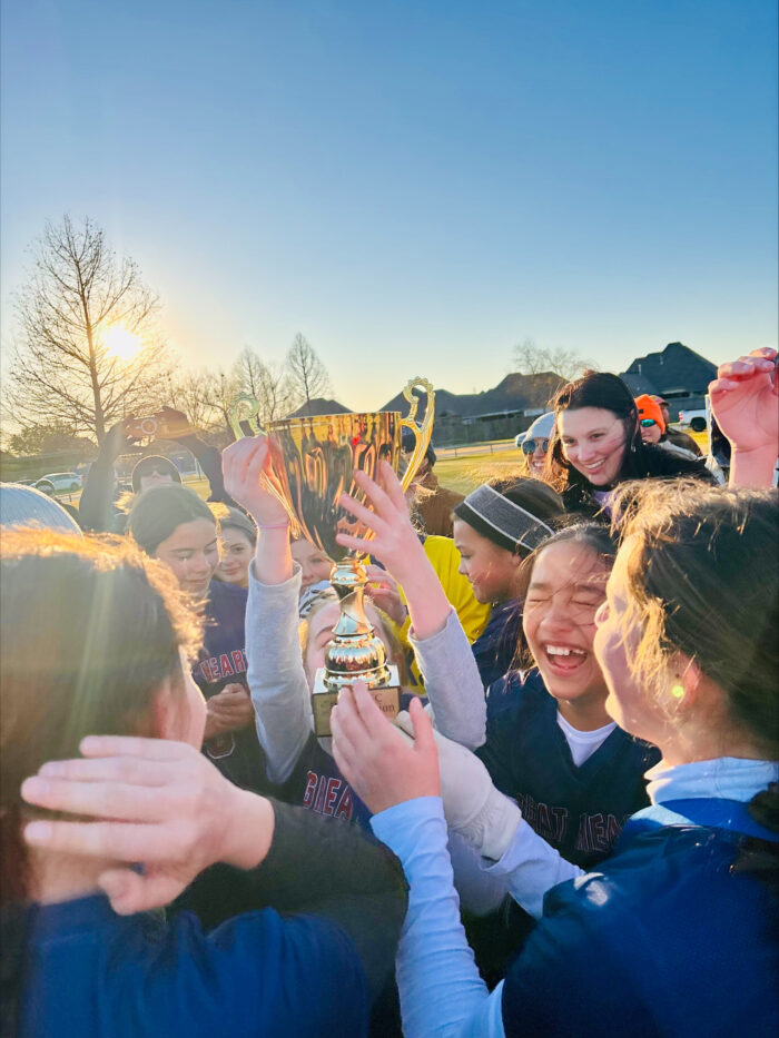 Student athletes holding up championship trophy