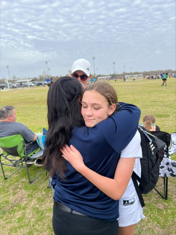 Girl hugging her coach after championship win