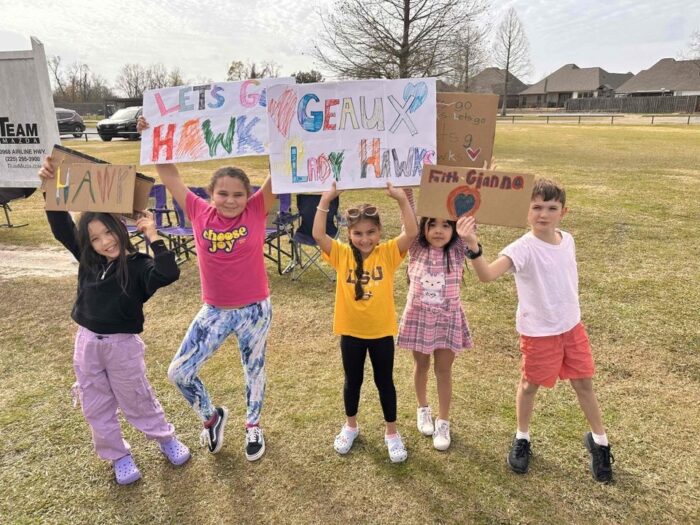 Group of children holding signs to cheer on the soccer team