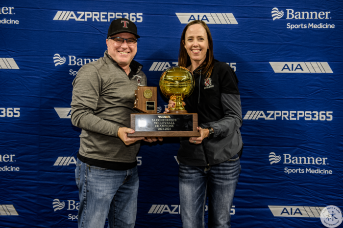 Picture of two coaches with state championship trophy.