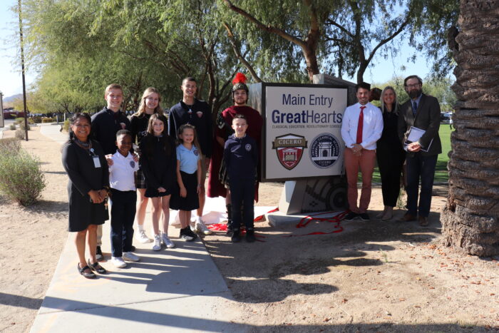 Faculty and students posing with the entry sign at Cicero.