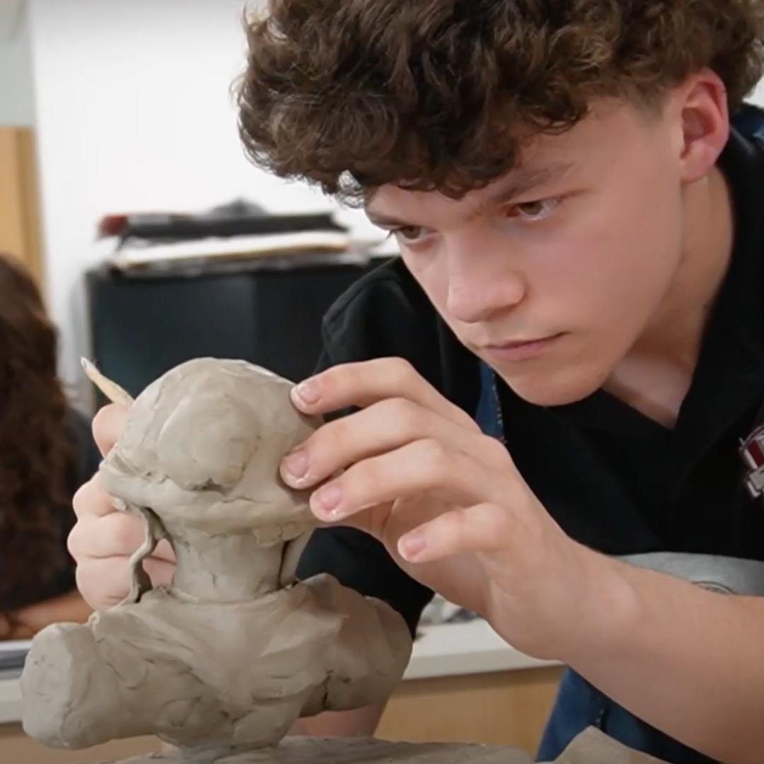 Student working on a clay sculpture.