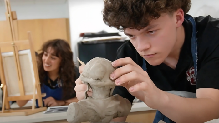 Student working on a clay sculpture.