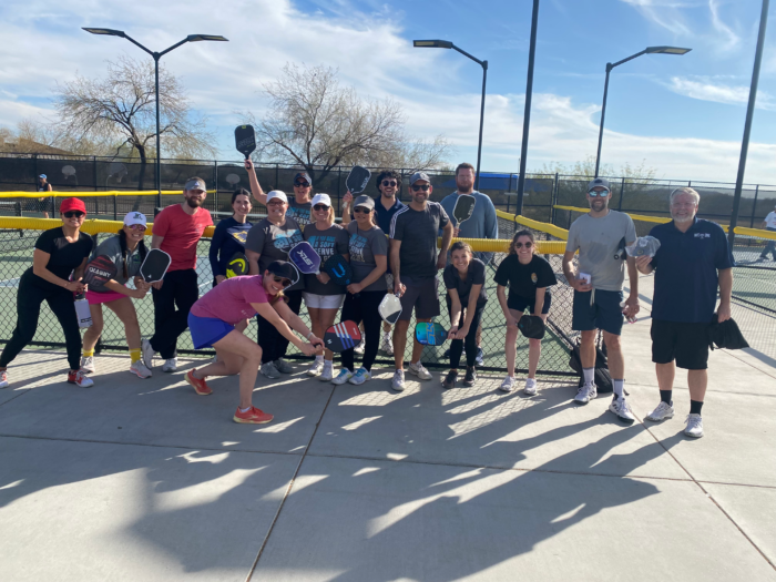 Faculty members posing on a pickle ball court