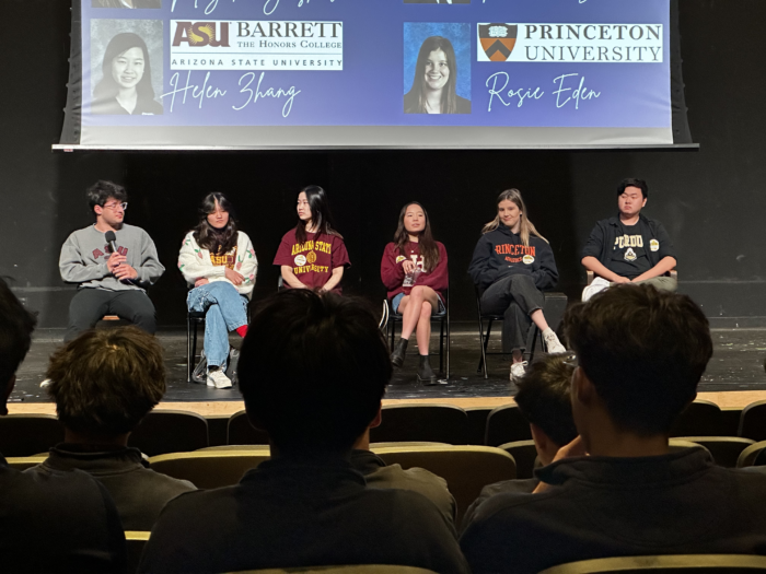 Panel of past students sitting on a stage